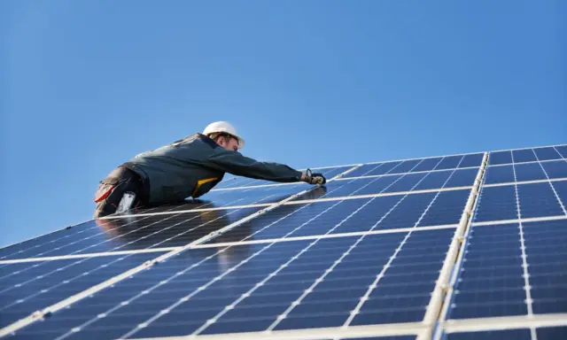 Instalator montuje panele fotowoltaiczne. Nowa ustawa o OZE jakie czekają nas zmiany w energetyce odnawialnej.